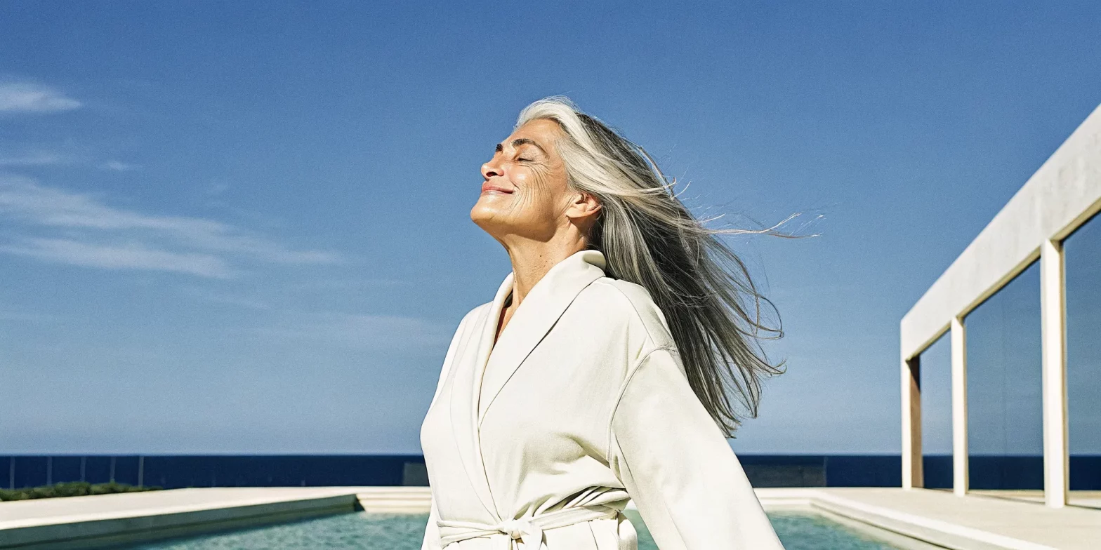 Woman with natural silver and gray hair, embracing her gray transition with confidence